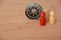 Wooden peoples with compass. A visionary businessman acts as a compass for their team, providing direction and inspiration to Royalty Free Stock Photo