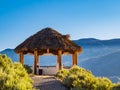 Wooden pergola at a beautiful green garden. Summer vacation, exotic pergola with palm leaves roof Royalty Free Stock Photo