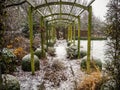 Wooden pergola structure during winter in a snow covered garden