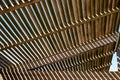 Wooden pergola in the sun with blue sky seen between boards Royalty Free Stock Photo