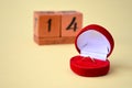 A perpetual calendar with February 14 and a red velvet gift box with a gold diamond ring. Concept of love and Valentines Day Royalty Free Stock Photo