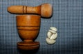 wooden pestle and mortar with garlic cloves on a textured Royalty Free Stock Photo