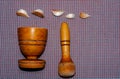 wooden pestle and mortar with garlic cloves on a textured Royalty Free Stock Photo