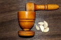 wooden pestle and mortar with garlic cloves on a textured senital Royalty Free Stock Photo