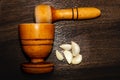 wooden pestle and mortar with garlic cloves on a textured Royalty Free Stock Photo