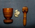 wooden pestle and mortar with garlic cloves on a textured Royalty Free Stock Photo