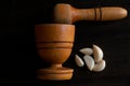 wooden pestle and mortar with garlic cloves on a textured Royalty Free Stock Photo