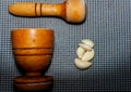 wooden pestle and mortar with garlic cloves on a textured Royalty Free Stock Photo