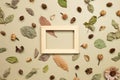 Wooden photo frame with autumn dry leaves on khaki brown background