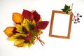 Wooden photo frame, a bouquet of colorful autumn leaves on a white background. Royalty Free Stock Photo