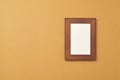 Wooden photo frame on brown background. Top view