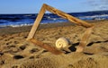 Wooden photo frame and shell on the sand by the sea on a Sunny day Royalty Free Stock Photo