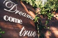 A wooden photozone, decorated with hops, with the inscription: `Dreams come true`.