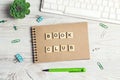 Wooden phrase Book club in workspace on paper notepad with computer keyboard, supplies and green plant on light wood background