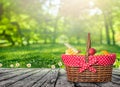 A wooden picnic table with picnic basket