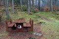 Wooden picnic table and benches in forest environment