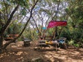 Wooden picnic table and benches surrounded by trees in rainforest mountain. A place to relax for people hiking in tropical forest