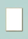 Wooden picture frame hanging on a light blue wall Royalty Free Stock Photo