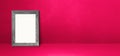 Wooden picture frame leaning on a pink wall. Horizontal banner Royalty Free Stock Photo