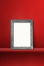 Wooden picture frame leaning on a red shelf. 3d illustration. Vertical background Royalty Free Stock Photo