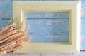 Wooden picture frame placed on a vintage wooden table with creamy grass bouquet flowers decorated