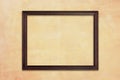 Wooden picture frame on retro yellow concrete wall Royalty Free Stock Photo