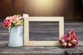 Wooden picture frame with rose paper flower in tinpot over blurred wood background Royalty Free Stock Photo