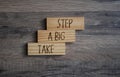 Wooden pieces with message Take a big step on wooden background