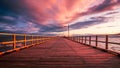 Wooden pier along sea with a purple and pink clouds at sunset sky Royalty Free Stock Photo