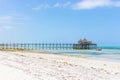 Wooden pier with boat and beach hut. Low tide of Indian Ocean. Idyllic exotic resort. Pier in perspective with bungalow. Royalty Free Stock Photo