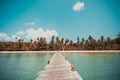 Wooden pier or bridge with tropical beach and sea in paradise is Royalty Free Stock Photo