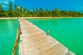 Wooden pier or bridge with tropical beach and sea in paradise is Royalty Free Stock Photo