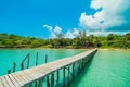 Wooden pier or bridge with tropical beach and sea in paradise is Royalty Free Stock Photo