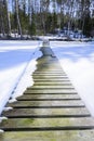 Wooden pier at the edge of a frozen lake in Finland.