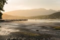 Golden Sunset over a Bay at Low Tide Surrounded by Forested Mountains Royalty Free Stock Photo