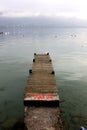 A wooden pier extends into a crystal clear alpine lake in Autumn, France Royalty Free Stock Photo