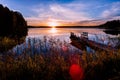 Wooden pier with fishing boat at sunset on a lake in Finland Royalty Free Stock Photo