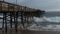 Wooden pier full of people with waves crashing under it Royalty Free Stock Photo