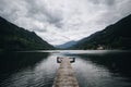 Wooden pier goes into pristine alpine lake Royalty Free Stock Photo