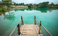 Wooden Pier on Green Blue Lagoon, Tropical Paradise. Traditional Bamboo Pier or Jetty on Lakeside. Concept of New Beginning of Exp Royalty Free Stock Photo