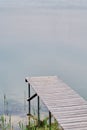 Wooden pier or jetty on blue lake sunset and sky reflection water. Royalty Free Stock Photo