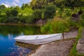 Wooden pier or jetty and a boat on lake sunset and sky reflection water. Royalty Free Stock Photo