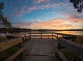 Wooden pier or jetty on lake sunset and sky reflection water Royalty Free Stock Photo