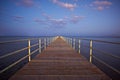 Wooden pier or jetty on sea sunset and sky reflection water Royalty Free Stock Photo