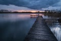 Wooden pier on the lake at cloudy sunset, view on a spring evening Royalty Free Stock Photo