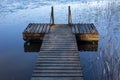 A wooden pier in a lake on a cold autumn day in southern Finland. Royalty Free Stock Photo