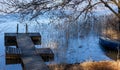 A wooden pier in a lake on a cold autumn day in southern Finland. Royalty Free Stock Photo