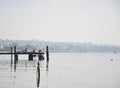 Wooden pier leading out into calm tranquil lake water. Bardolino, Italy