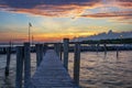 A wooden pier leading to a lake on Lake Neusiedl in Podersdorf, Austria. In the background is a dramatic sky at sunrise Royalty Free Stock Photo