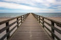 Wooden pier leads straight over the beach and the sea to the horizon, concept for the way forward into an uncertain future, copy